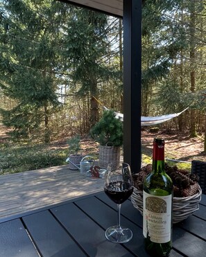 A bottle of wine and a glass on a table with a view of a forest. - Summer house Fauna Hou Hals 300 m from the sea (Hals)
