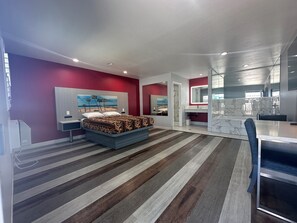 Ein modernes Schlafzimmer mit Bett, Schreibtisch und Bad.