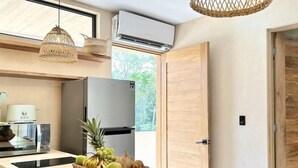 A modern kitchen with a central island, a refrigerator, and a hanging light fixture. - COCAY PI 2218, Relax, Enjoy, and Connect (Tulum)