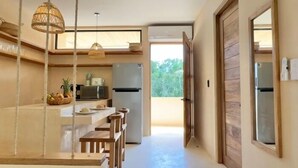 A modern kitchen with a central island, wooden chairs, and hanging lights. - COCAY PI 2223,Sumérgete en Tranquilidad&Belleza (Tulum)