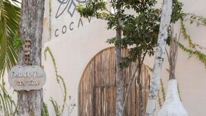 Un edificio rustico con un'ampia porta in legno e un cartello con su scritto 'Casa del Sol Cocah'.