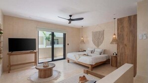 Una camera da letto moderna con un letto, una televisione, una ventola a soffitto e un'ampia finestra.