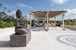A Buddha statue, a hammock, and a covered seating area with a patterned floor. - COCAY 113, Vistas, Diseño y Serenidad-2 (Tulum)