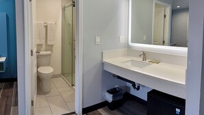 A bathroom with a shower, toilet, and a large mirror above the sink. - La Casa Motel Burbank Airport - LA (Sun Valley)
