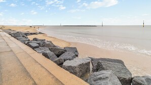 A beach with a rocky breakwater and calm sea. - 4 bedroom accommodation in Sea Palling (Sea Palling)