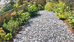 A garden pathway with a wooden fence and various plants. - 4 bedroom accommodation in Combe Martin (Combe Martin)