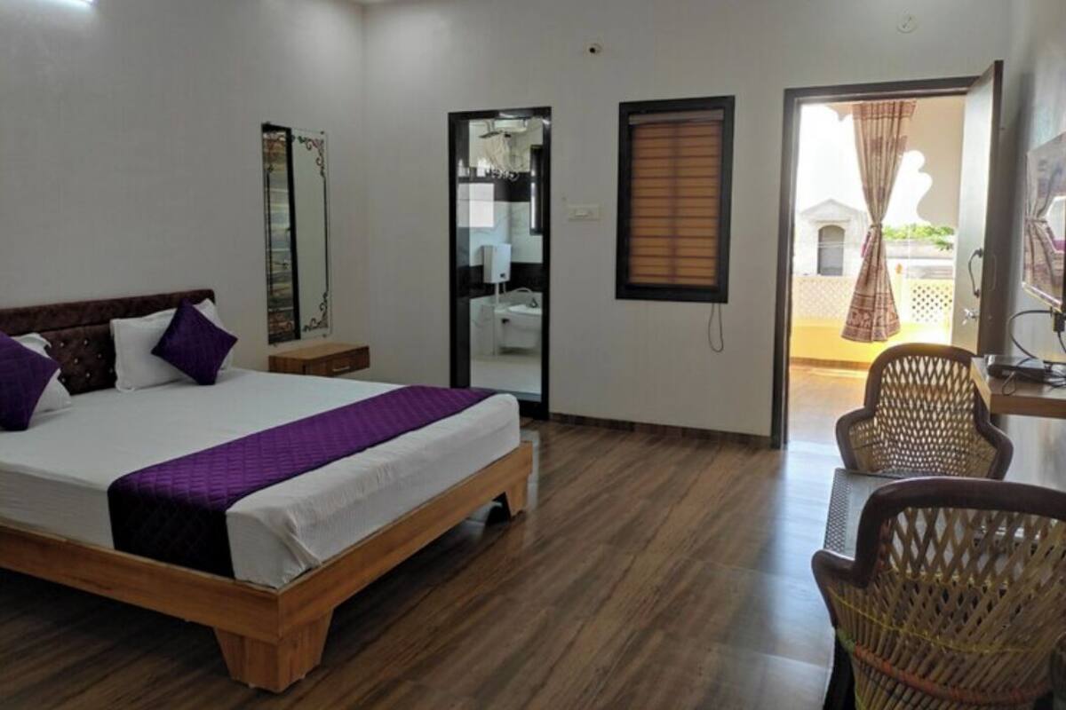 Une chambre à coucher avec un lit en bois, un miroir, une armoire et une chaise.
