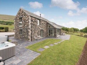 A stone house with a patio, outdoor seating, and a hot tub. - 4 bedroom accommodation in Threlkeld, near Keswick (Threlkeld, near Keswick)