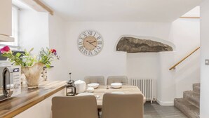 Une cuisine moderne avec un plan de travail en bois, une machine à café et un vase rempli de fleurs.