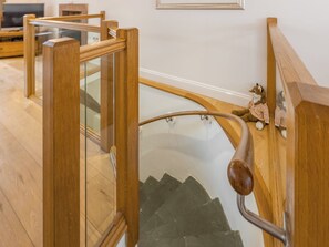 A wooden staircase with glass railings and a handrail. - 3 bedroom accommodation in Keswick (Keswick)