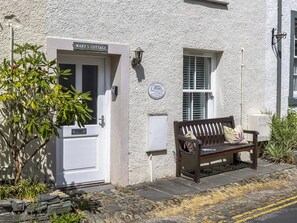 A white cottage with a sign reading "Mary's Cottage" and a bench outside. - 3 bedroom accommodation in Keswick (Keswick)