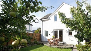 A house with a paved patio, a wooden fence, and a grassy yard. - 2 bedroom accommodation in Keswick (Keswick)