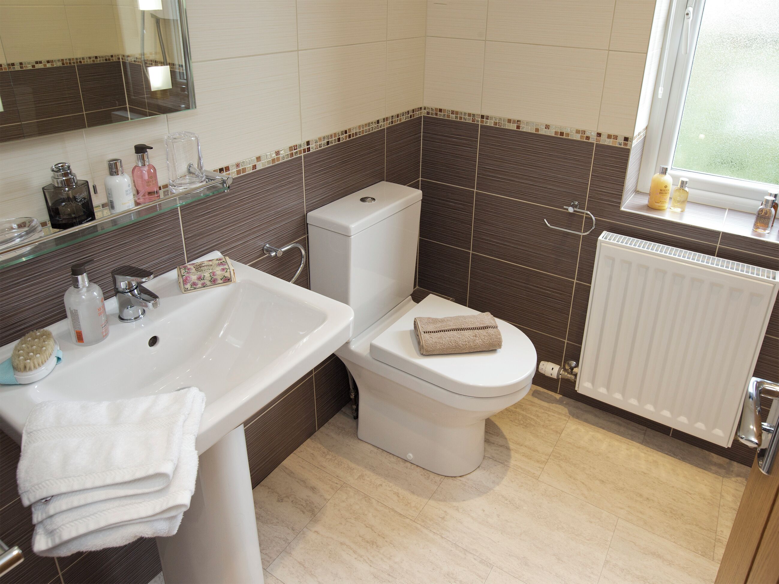 A bathroom with a white sink, a toilet, and a window.