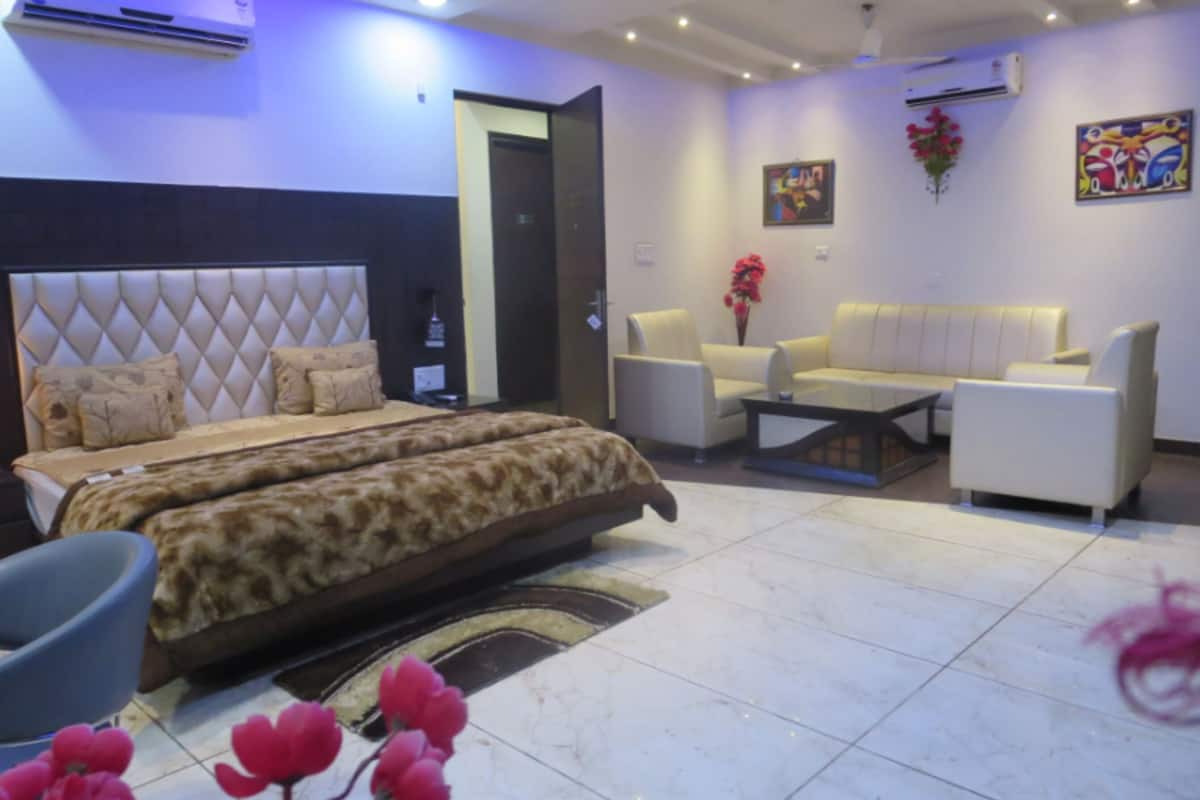 A modern bedroom with a large bed, a sofa, and a coffee table.