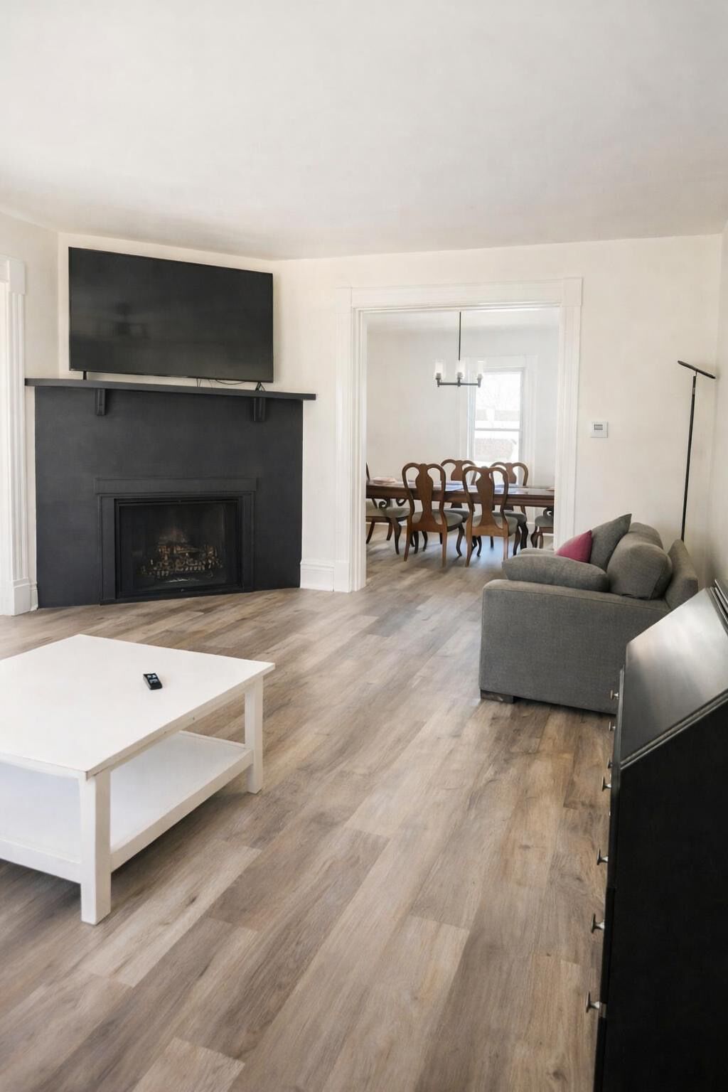 Un salon moderne avec une cheminée, un coin repas et un canapé.