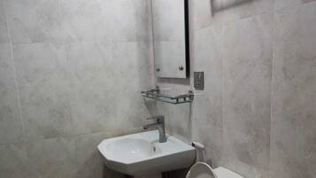A bathroom with a toilet, sink, and a towel rack.