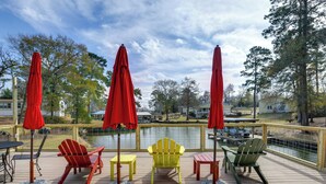 A deck with outdoor seating, a view of a body of water, and a wooden railing. - Private Hot Tub & Dock! Lakefront Log Cabin Oasis (Onalaska)