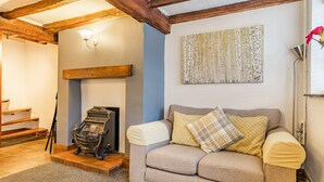 Ein gemütliches Wohnzimmer mit Sofa, Kamin und Treppe.