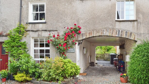 Ein steinerer Bogen führt zu einem Gebäude mit der Aufschrift "Brock Cottage".