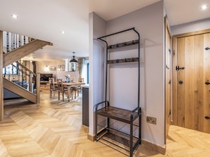 Ein modernes Interieur mit Fischgrätparkett, einer Treppe, einem Essbereich und einer Holztür.