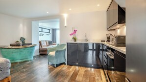 Eine moderne Küche mit schwarzem Arbeitsplatz, Edelstahlgeräten und Holzboden.