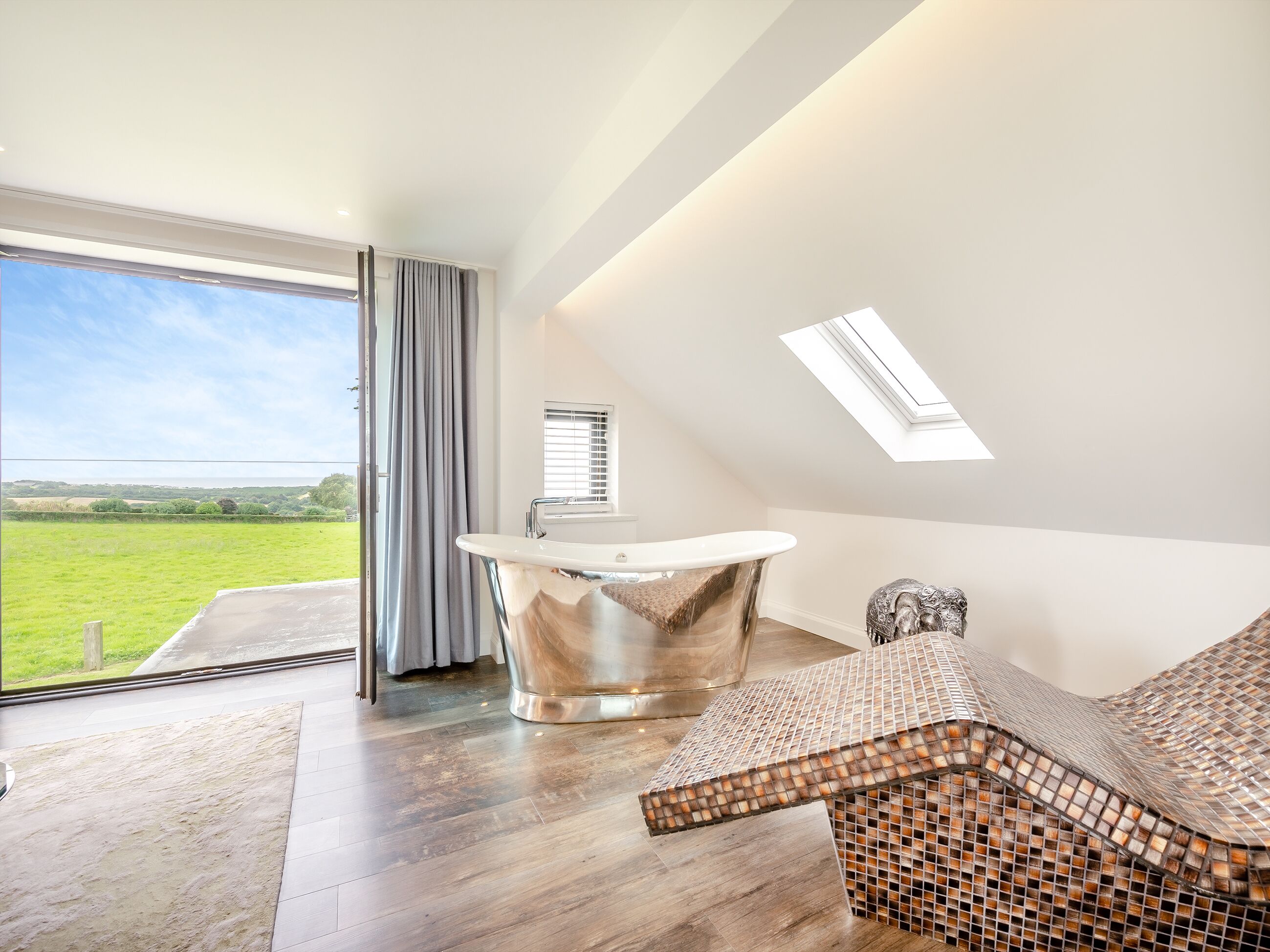 Ein modernes Badezimmer mit einer freistehenden Badewanne, einem Fenster mit Jalousien und einem Oberlicht.