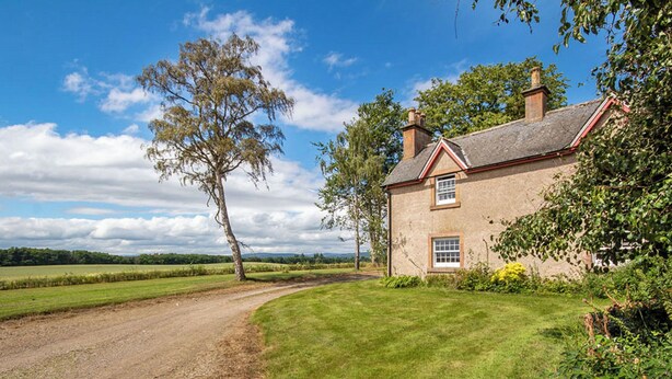 A rural house with a dirt path leading to it, surrounded by greenery and fields. - 2 bedroom accommodation in Kildary, near Tain (Kildary, near Tain)