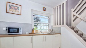 A kitchen with a microwave, sink, and cabinets. - 2 bedroom accommodation in Kildary, near Tain (Kildary, near Tain)