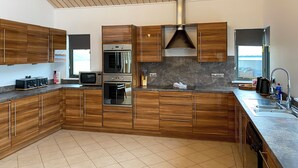 Una cucina moderna con mobili in legno, elettrodomestici in acciaio inossidabile e un'ampia finestra.