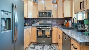 Una cocina moderna con armarios de madera, electrodomésticos de acero inoxidable y un salpicadero de ladrillo.