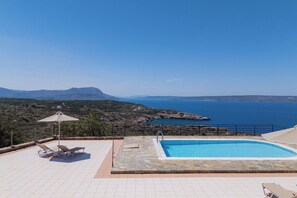 A pool area with lounge chairs and a view of the sea and mountains. - Villa Pi - Villa with a pool and splendid sea views (Vámos)