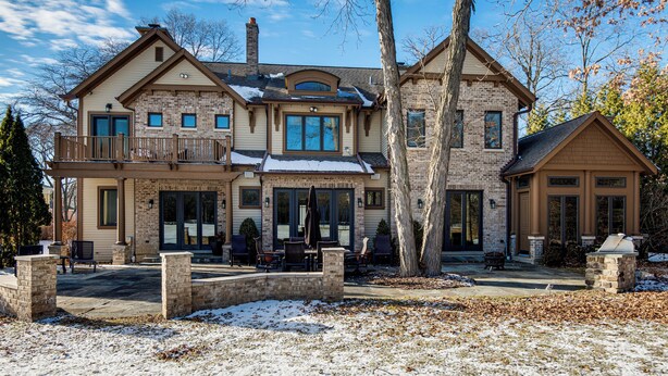 A two-story house with a balcony, a covered patio, and a stone fireplace. - 1 Mi to Metra: Estate w/ Theater, Game Room & More (Northbrook)