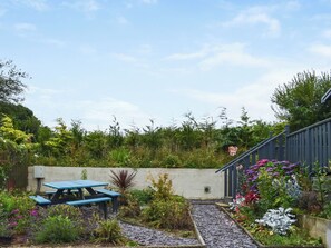 A garden with a picnic table, a gravel path, and various plants and flowers. - Edmonton Lodge - UK50308 (Doublebois, near Liskeard)