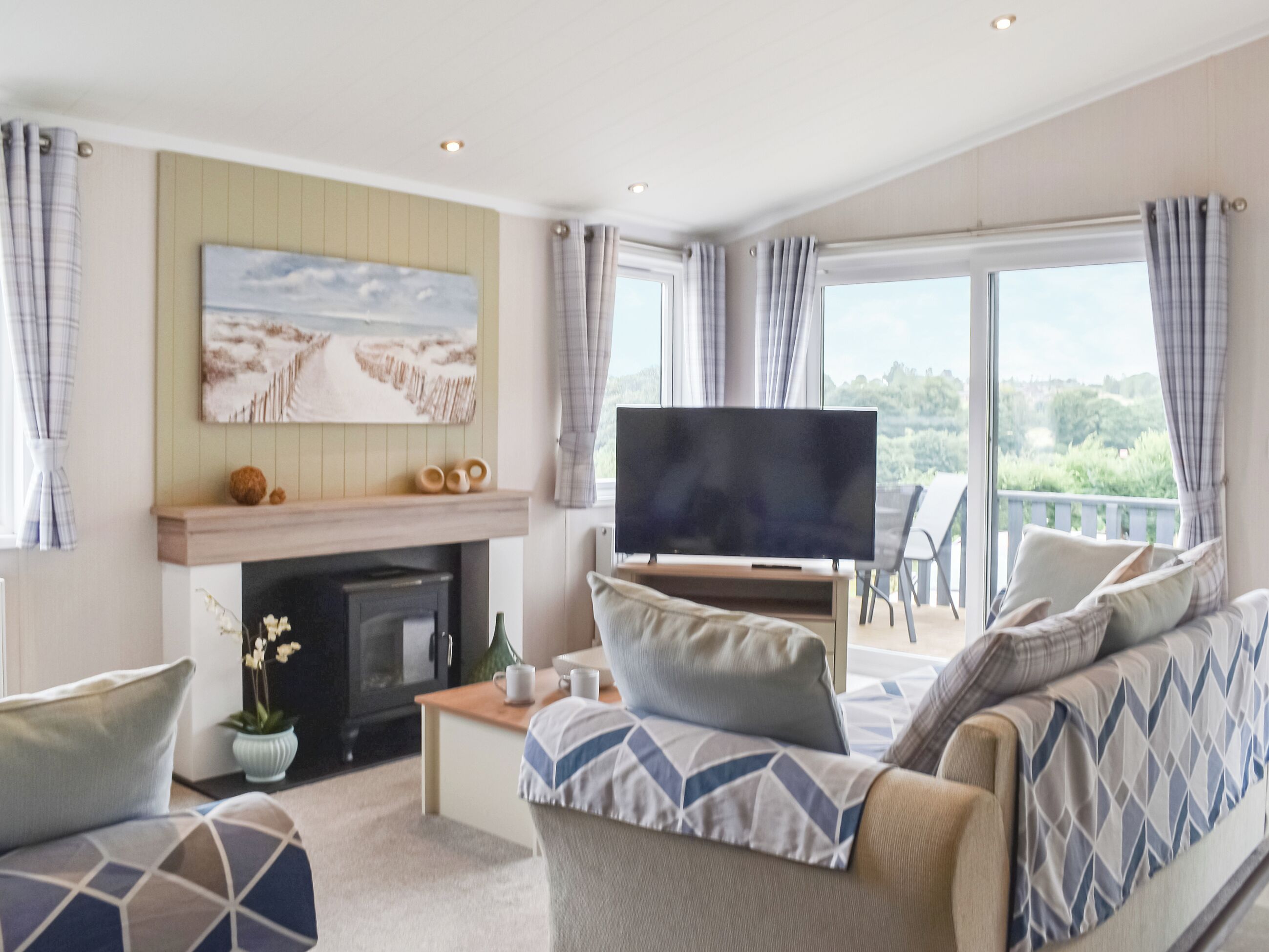 A living room with a fireplace, a flat-screen TV, and a sofa.
