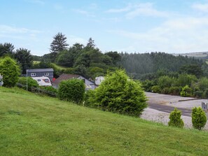 A rural landscape with houses, a gravel path, and dense greenery. - Edmonton Lodge - UK50308 (Doublebois, near Liskeard)