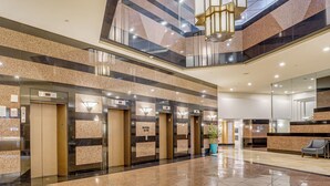 A spacious lobby with a polished floor, multiple elevators, and a reception area. - Free Parking Pool Harbor View Access Honolulu Gem! (Honolulu)