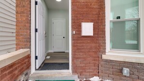 Un pasillo estrecho con una puerta blanca.
