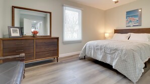 Une chambre à coucher avec un lit, une commode et un ventilateur de plafond.