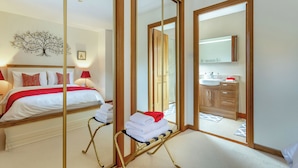 Een hotelkamer met een bed, een spiegel, een badkamer met een wastafel en uitzicht op buiten.
