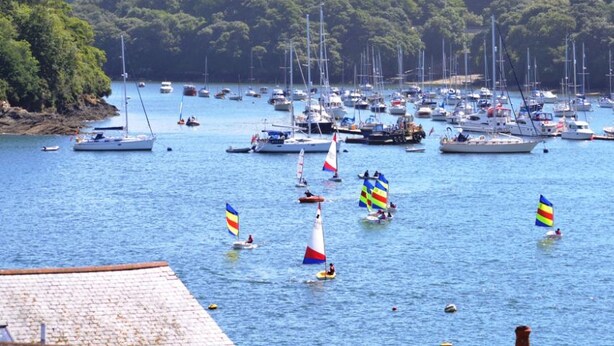 Una marina con diverse barche a vela e yacht ormeggiati.