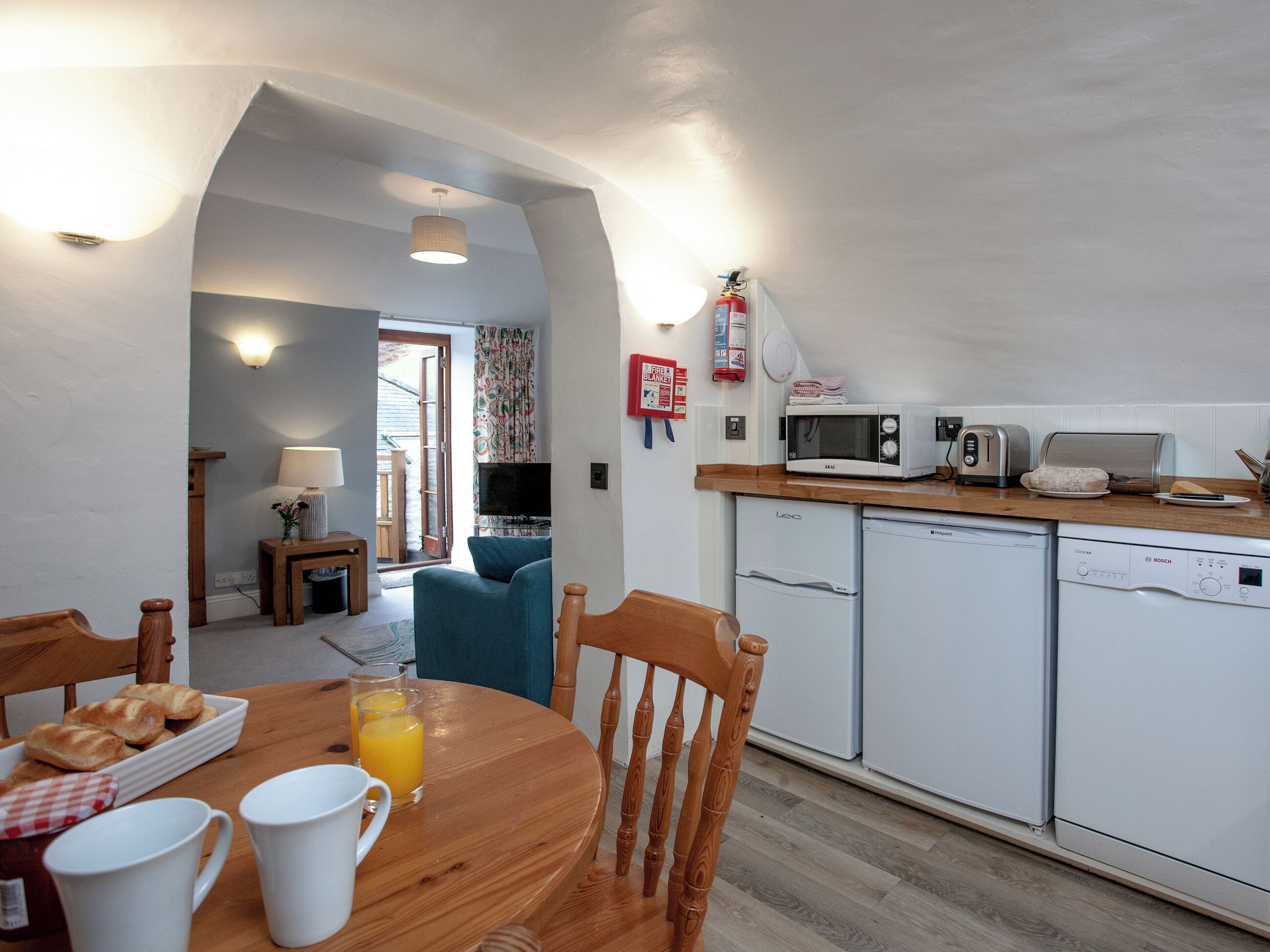 A compact kitchen with a microwave, toaster, and dishwasher.