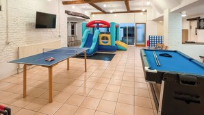 A room with a ping pong table, a pool table, and a children's play area with inflatable structures. - Sunflower Bungalow - UK50569 (Little Dunham, near Kings Lynn)