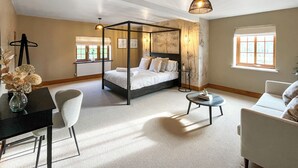 A four-poster bed in a well-lit room with a view of the outdoors through a window. - 5 bedroom accommodation in St. Asaph (St. Asaph)