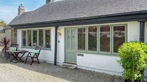 A house with a gravel driveway, a green door, and a sign reading "ATLANTIC". - Atlantic Cottage - UK48935 (Crowlas, near Penzance)