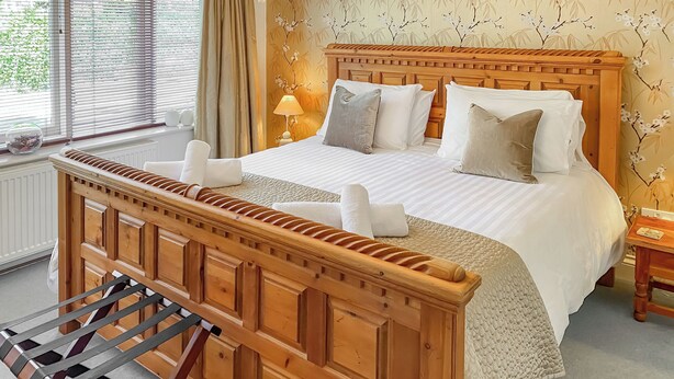 A neatly arranged bedroom with a wooden headboard, a bed with white linens, and a bedside table. - Atlantic Cottage - UK48935 (Crowlas, near Penzance)