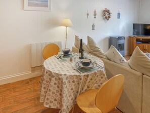 A dining area with a round table, chairs, a lamp, and a bottle of wine. - Atlantic Cottage - UK48935 (Crowlas, near Penzance)