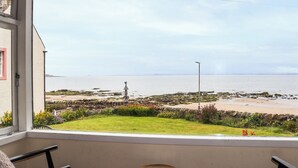 Een balkon met uitzicht op een strand en de zee.