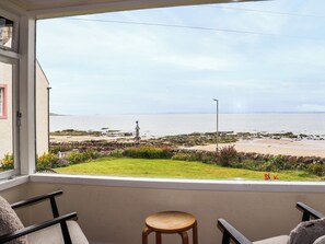 Ein Balkon mit Blick auf Strand und Meer.