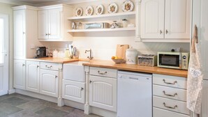 A kitchen with white cabinetry, a bread maker, a toaster, and a microwave. - 3 bedroom accommodation in Bettiscombe, near Lyme Regis (Bettiscombe, near Lyme Regis)