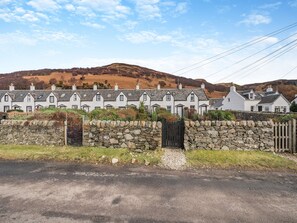 A row of white houses with stone walls and a stone gate. - 10 The Apostles - UK37312 (Lochranza)